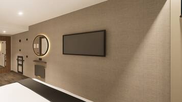 A modern hotel room with a large bed, a flat-screen TV, a round mirror, and a small seating area.