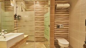 Un baño moderno con ducha de vidrio, lavamanos y retrete.