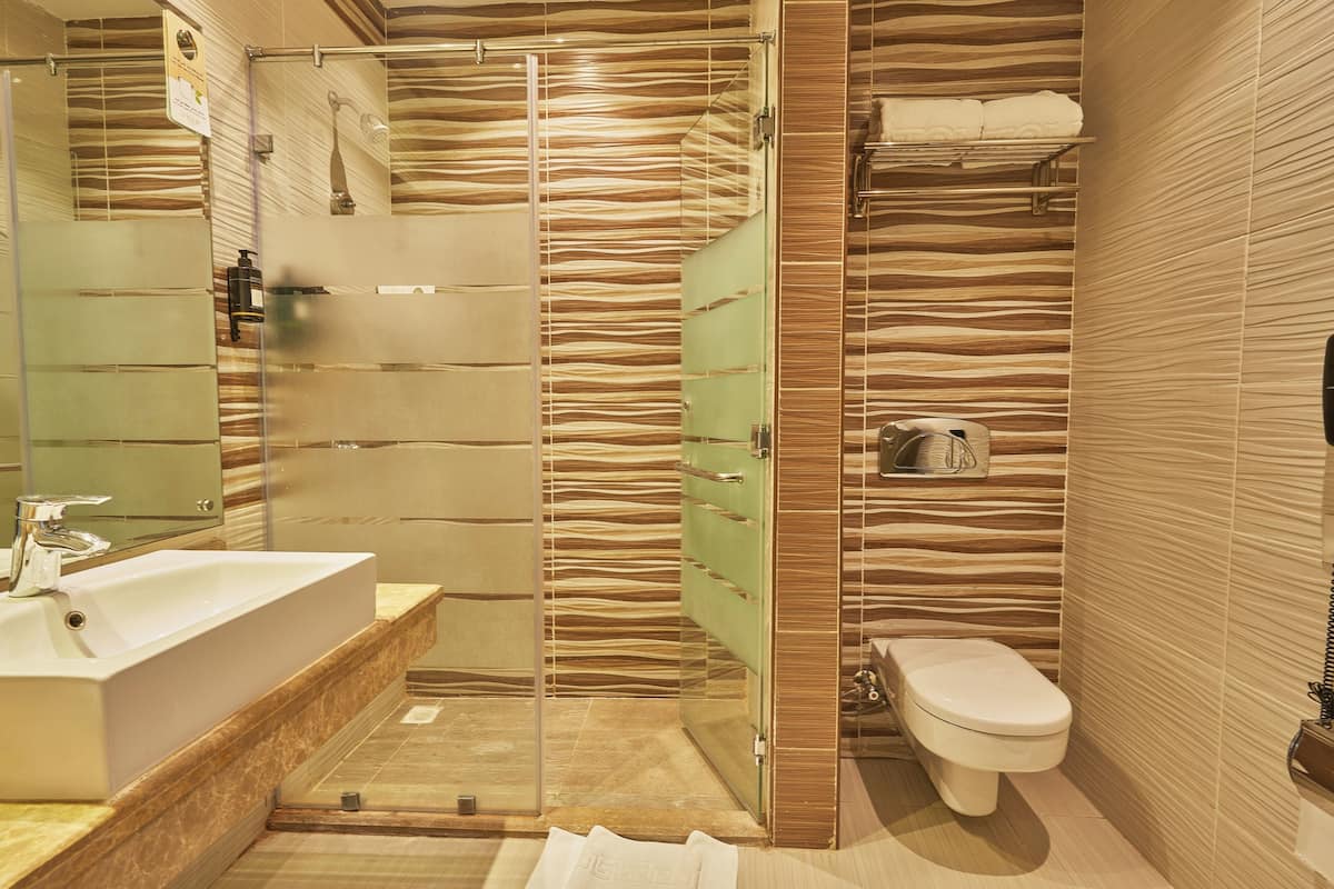 Un baño moderno con ducha de vidrio, lavamanos y retrete.
