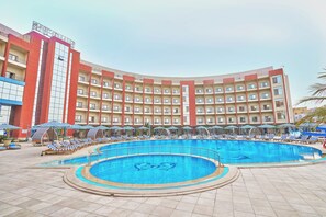 A hotel with a large pool, multiple balconies, and lounge chairs. - Tolip El Narges New Cairo (New Cairo)