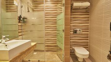 A modern bathroom with a glass-enclosed shower, a sink, and a toilet.