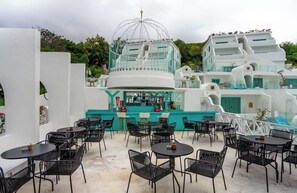 Een wit gebouw met een bar, terras en een koepelconstructie.
