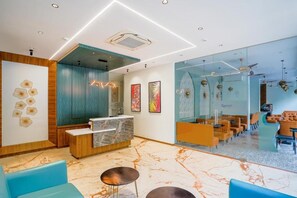 A modern hotel lobby with a reception desk, seating area, and a glass partition. - Apex Beacon Hotel Andheri Mumbai (Mumbai)