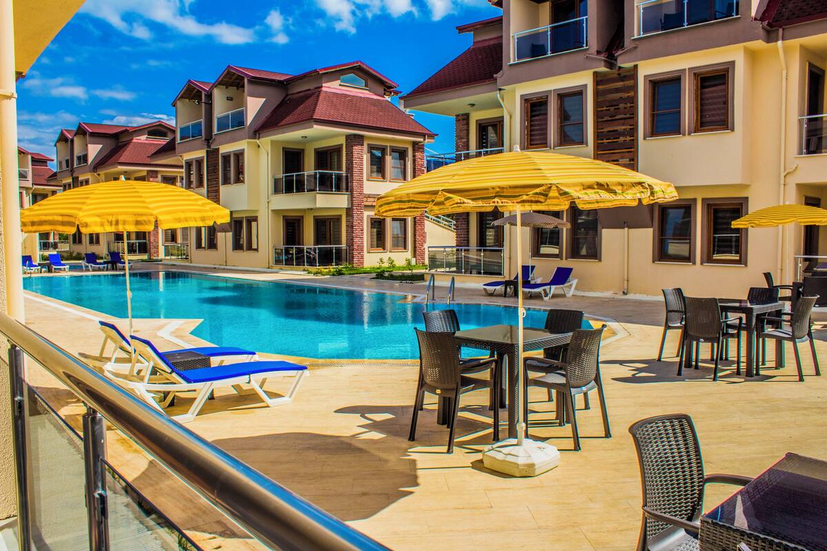 A poolside area with lounge chairs, umbrellas, and outdoor seating.