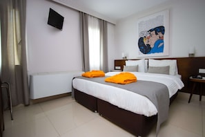 Ein Hotelzimmer mit Bett, Nachttisch, Wandfernseher und einem Poster an der Wand.
