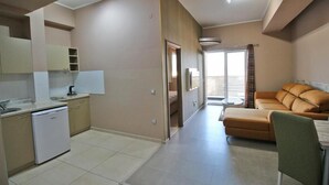 Una cocina moderna con lavavajillas, un comedor con mesa y sillas, y una sala de estar con sofá.