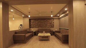 Un salon moderne avec un mur en pierre, deux canapés, une table basse et un éclairage encastré.