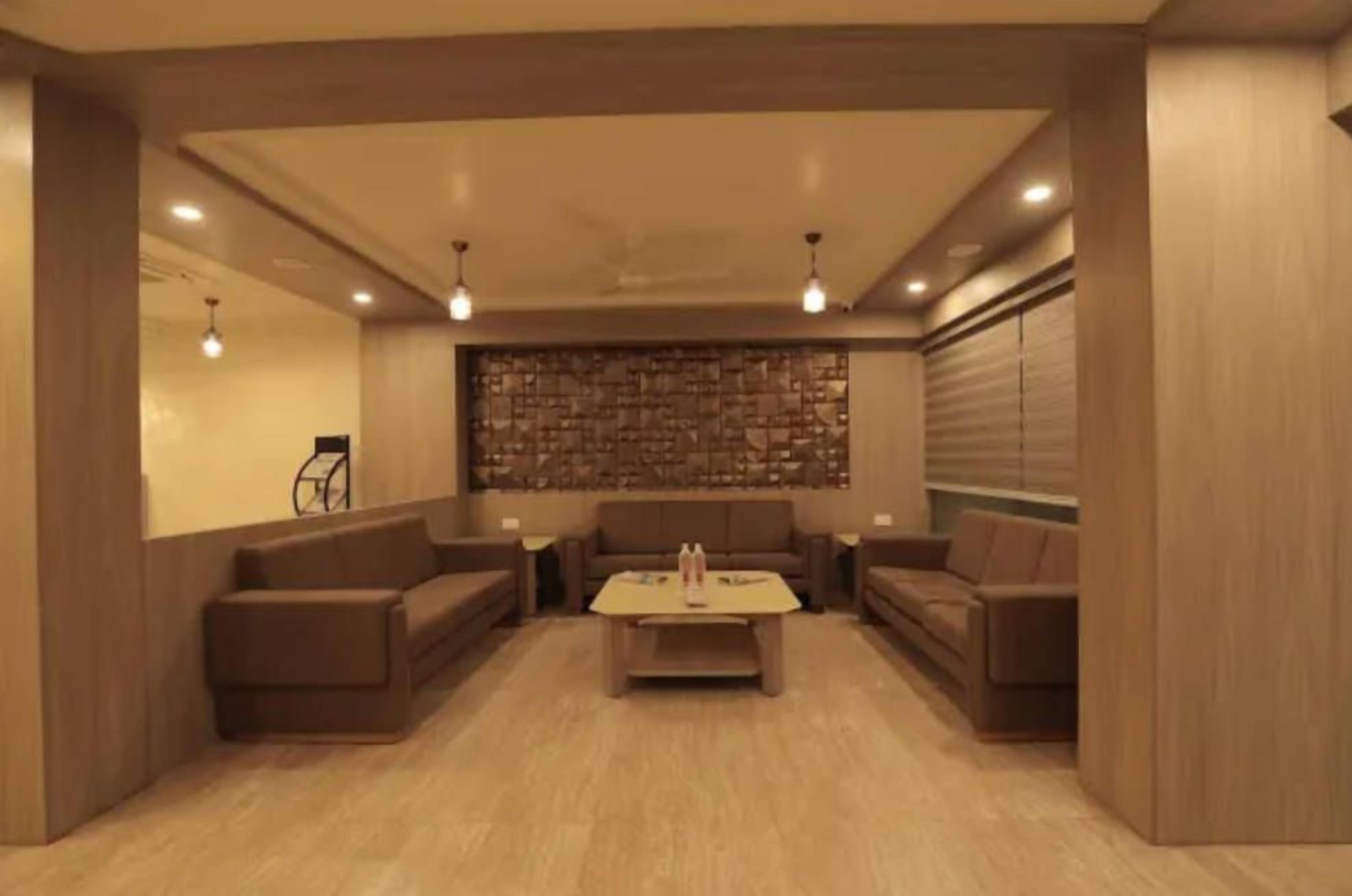 Uma sala de estar moderna com parede de pedra, dois sofás, uma mesa de centro e iluminação embutida.
