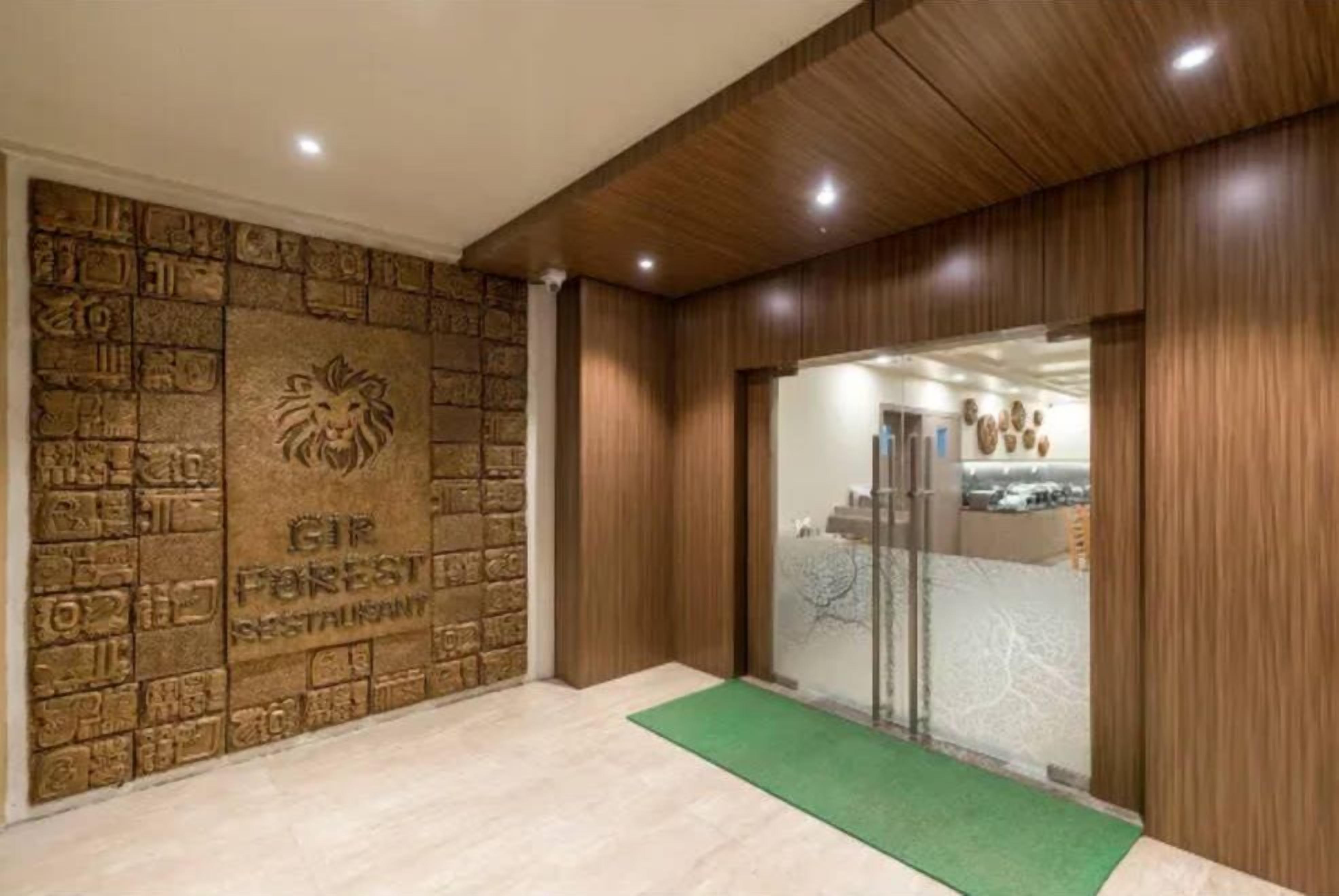 Una zona de recepción con pared de piedra, un emblema de león y un felpudo verde.