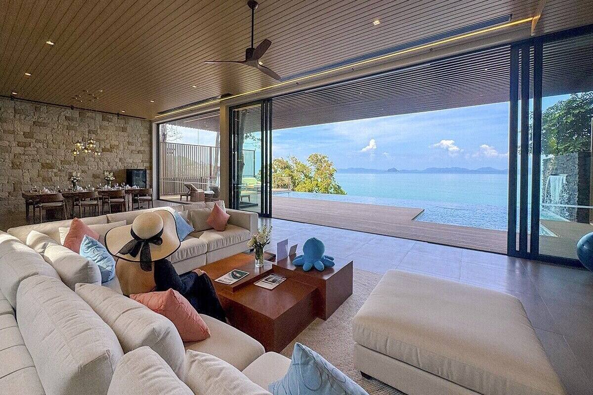 Un salón moderno con un sofá grande, una mesa de centro y vistas al mar.