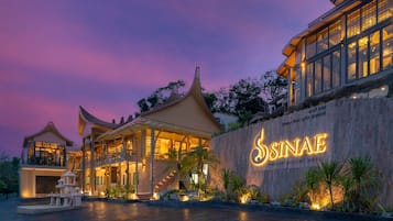 A luxury hotel with a traditional architectural style, featuring a prominent entrance and a well-lit facade.