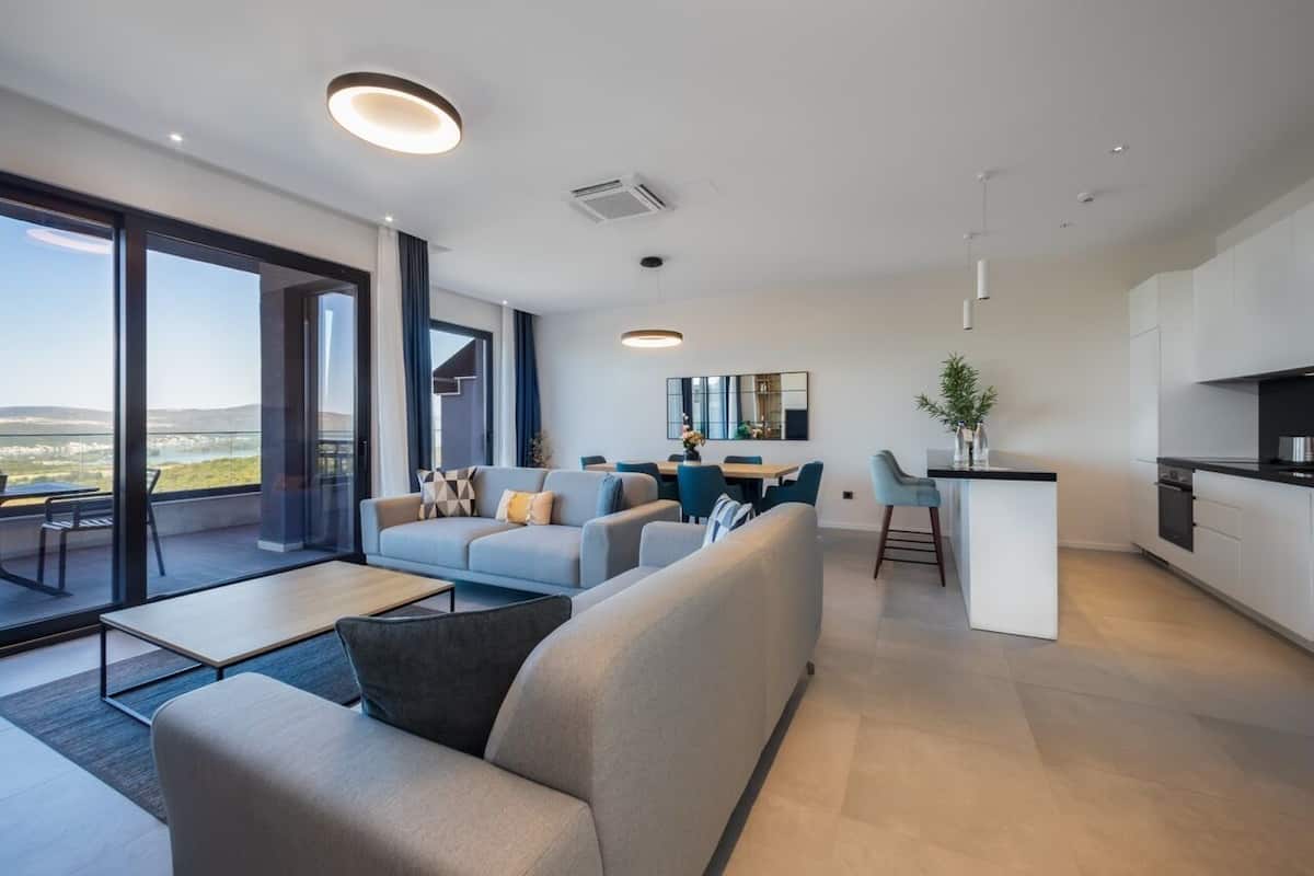 Una sala de estar moderna con un sofá, un comedor y una cocina.
