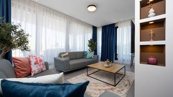Sala de estar moderna com sofá, mesa de centro e objetos decorativos.