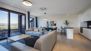 Un salon moderne comprenant un canapé, un coin repas et une cuisine.