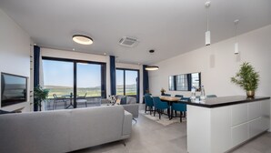 Una cocina moderna con comedor, ventanas amplias y vista al paisaje.