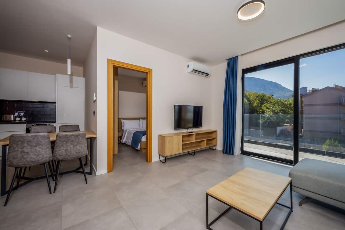 Una sala de estar moderna con televisor, sofá y zona de comedor.