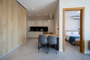 A modern interior with a dining area, kitchen, and bedroom.