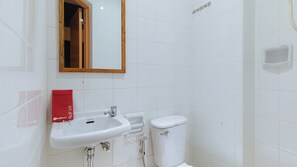 Un baño con lavamanos blanco, inodoro y espejo.
