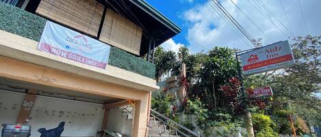 Un bâtiment sur lequel on peut voir une enseigne pour Coco-Shack, une autre pour The Aidz Inn, et une troisième pour un établissement proposant à la fois un bar-restaurant et des séances de karaoké.