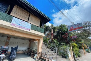 Un edificio con un letrero que dice Coco-Shack, un letrero que indica The Aidz Inn y un letrero para un Restobar & Videoke.