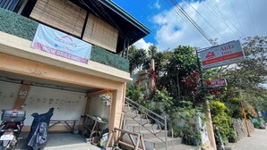 A building with a sign for Coco-Shack, a sign for The Aidz Inn, and a sign for a Restobar & Videoke.