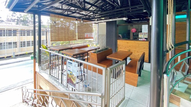An indoor seating area with tables and chairs, a counter, and a view of the outside.