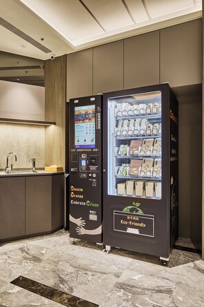 A vending machine with a digital screen and a selection of packaged goods. - Orange Hotel - Hanzhong Taipei (Taipei)