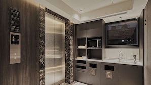 A modern bathroom with a marble floor, a built-in sink, a mirror, and a digital elevator panel. - Orange Hotel - Hanzhong Taipei (Taipei)