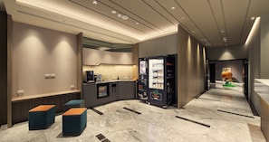 A modern hotel lobby with a reception desk, seating area, vending machines, and a children's play area. - Orange Hotel - Hanzhong Taipei (Taipei)