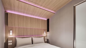 A modern hotel room with a wooden headboard, bedside lamps, and a large bed. - Orange Hotel - Hanzhong Taipei (Taipei)