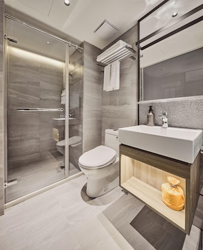 Ein modernes Badezimmer mit Duschkabine aus Glas, Toilette, Waschtisch inklusive Spiegel und Handtuchhalter.