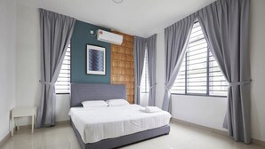 Een moderne slaapkamer met een bed, een raam met zonwering, een wandairconditioner en grijze gordijnen.