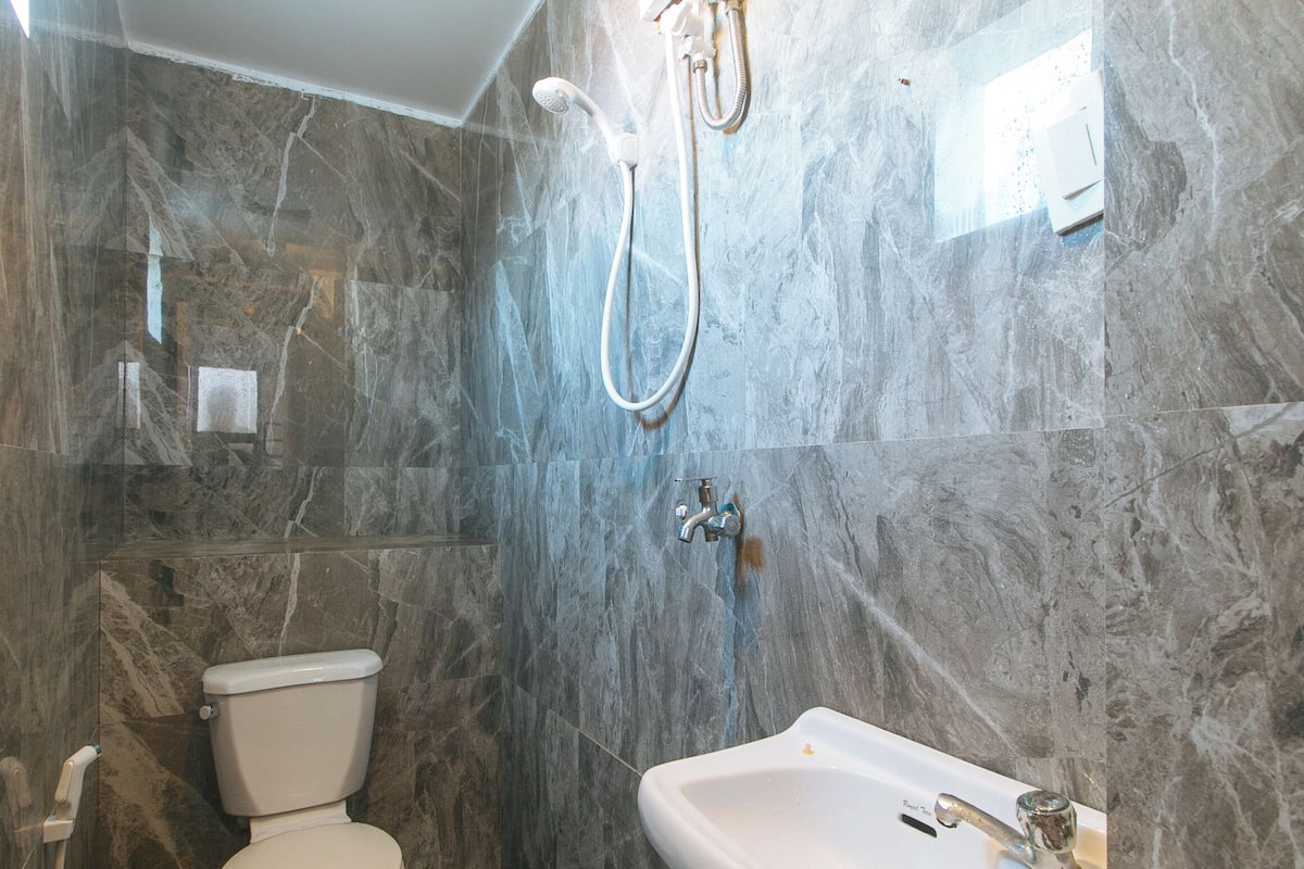 A bathroom with a toilet, a sink, and a shower.