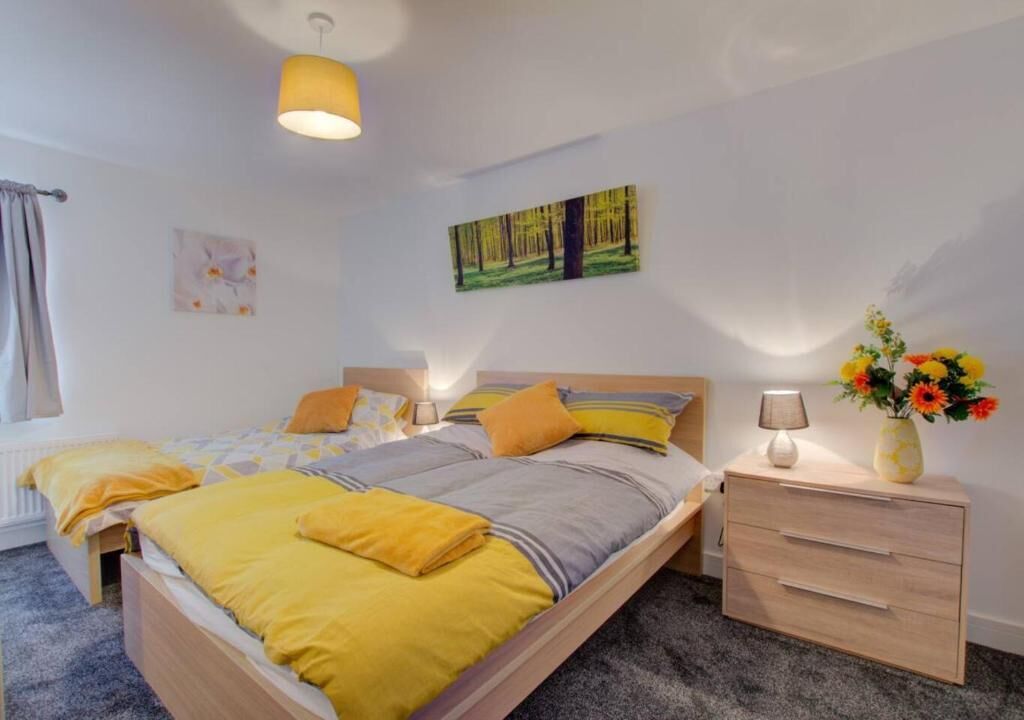 A bedroom with a bed, bedside tables, a lamp, and a painting on the wall.