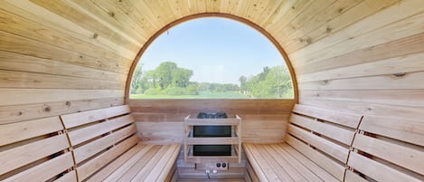 A sauna with wooden benches and a view through an arched opening.