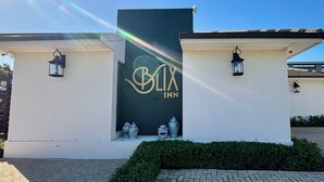A building with a sign reading 'BIX INN' and two lantern-style lights on the walls. - Blix Inn (Stellenbosch)