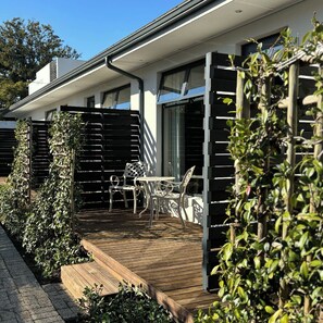 A modern house with a patio, outdoor furniture, and a wooden deck. - Blix Inn (Stellenbosch)