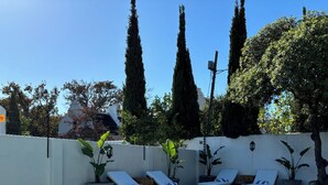 A rectangular pool with clear water, surrounded by white walls and tall trees. - Blix Inn (Stellenbosch)