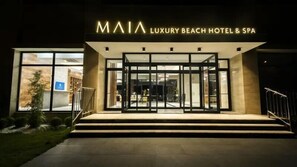 Exterior del MAIA Luxury Beach Hotel & Spa, con una entrada moderna y puertas de vidrio.