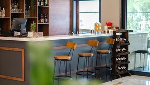 A bar area with stools, a wine rack, and a cash register. - Maia Beach Hotel (Aydın)