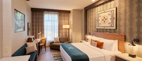A hotel room with a bed, a desk, a chair, and a window with curtains.