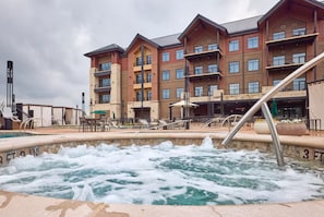 A hotel with a pool area, outdoor seating, and a building with multiple balconies. - Choctaw Landing Casino & Resort, Trademark Coll (Broken Bow)