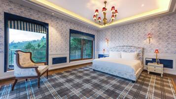 A bedroom with a large bed, a chair, a nightstand, a lamp, and a window with a view of greenery.