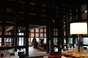A library with bookshelves, tables, and chairs. - Bon-yado Uakita Nishimonai (Ugo)