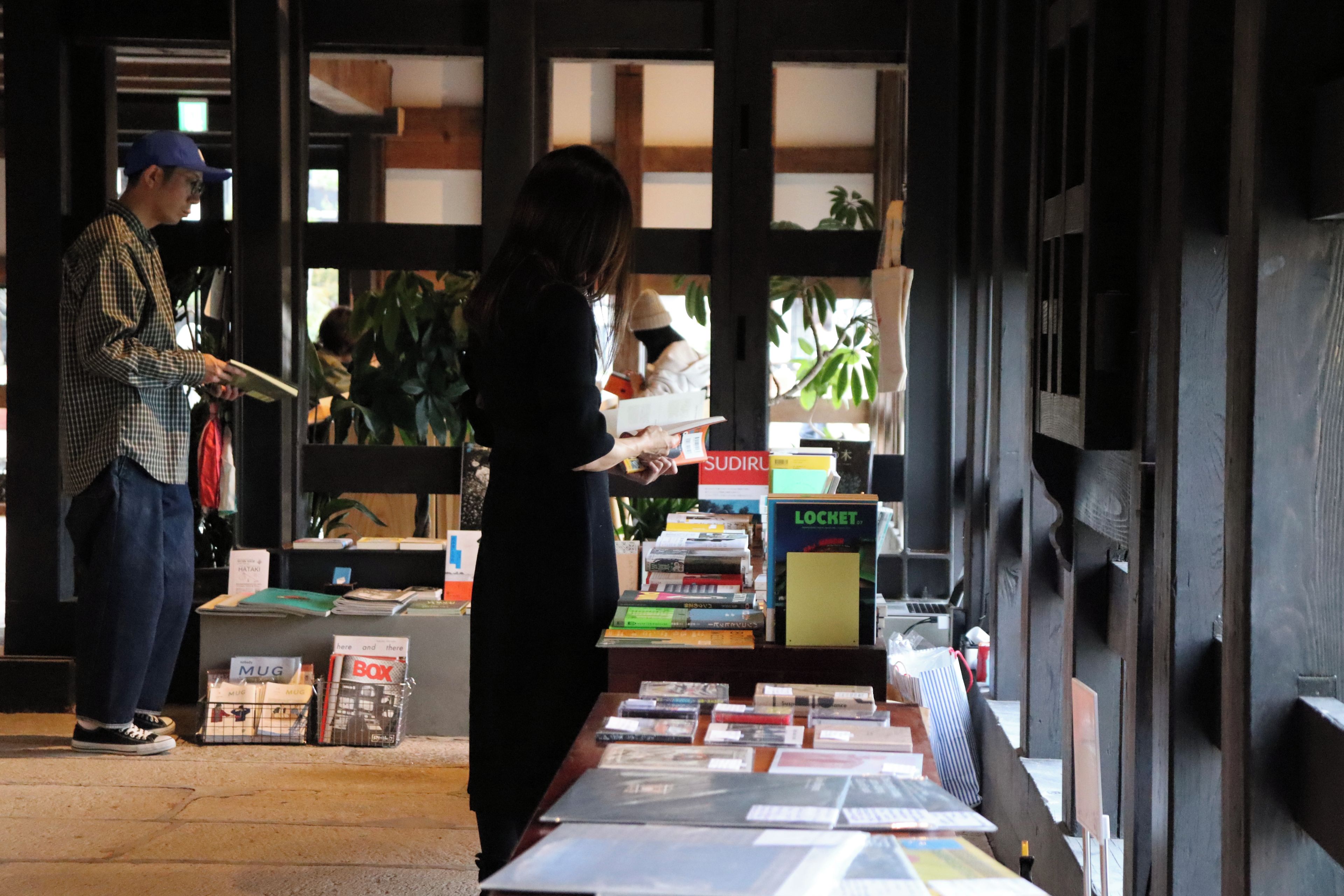 A bookstore with bookshelves and a table displaying books and magazines.