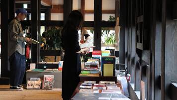 A bookstore with bookshelves and a table displaying books and magazines.