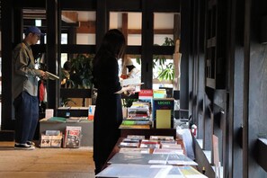 A bookstore with bookshelves and a table displaying books and magazines. - Bon-yado Uakita Nishimonai (Ugo)