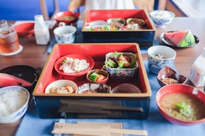 A table with various dishes and bowls, including rice, vegetables, and soup. - Bon-yado Uakita Nishimonai (Ugo)