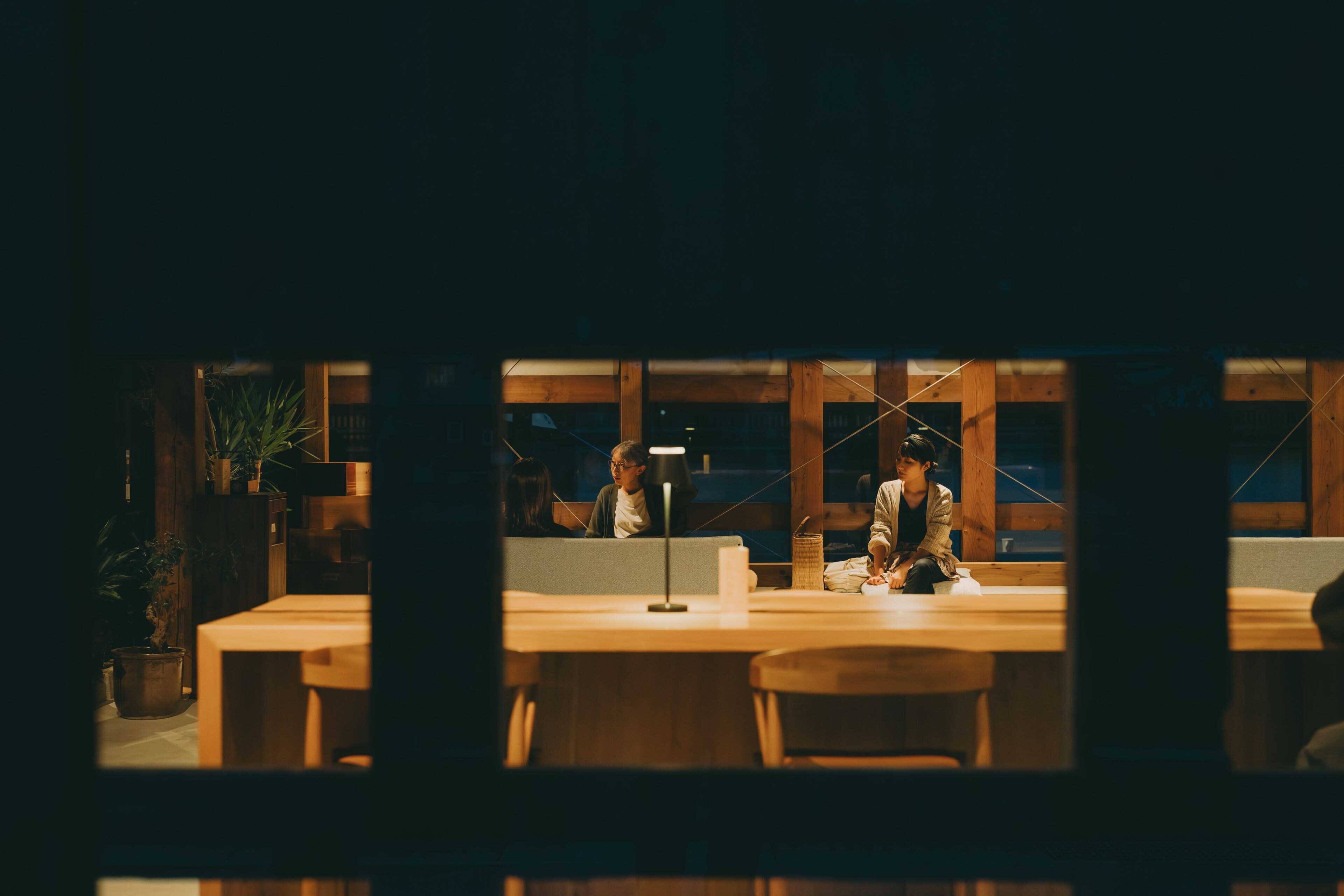A dimly lit room with wooden furniture and a large window.