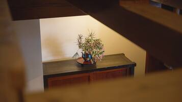 A wooden table with a vase of flowers and a teapot.